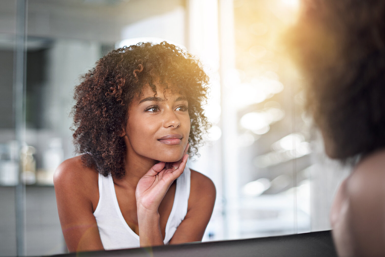 Woman looking in mirror admiring her skin